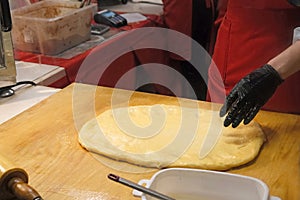 Chef prepare dough for traditional czech bakery trdelnik, national pastry food on street Christmas market