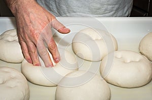 The chef prepares the balls of pizza dough on the floured table.Food, italian cuisine and cooking concept. Preparation of the Ital