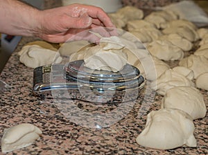 The chef prepares the balls of pizza dough on the floured table.Food, italian cuisine and cooking concept. Preparation of the Ital