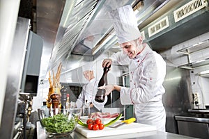 The chef prepares a dish in the kitchen of restoran.