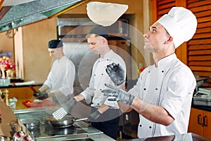 The chef prepares food in front of the visitors in the restaurant