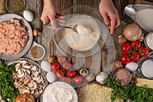 Chef prepares kneading dough, ingredients background.On old wooden table, cooking pizza or pie, top view flat lay