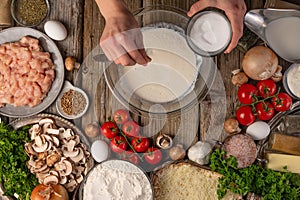 Chef prepares kneading dough, ingredients background.On old wooden table, cooking pizza or pie, top view flat lay