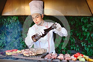 The Chef prepares meat on the barbecue.