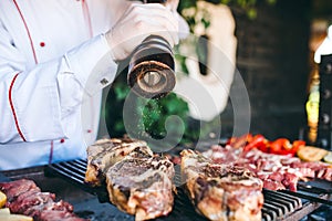 The Chef prepares meat on the barbecue.