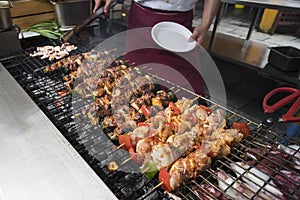 Chef prepares meat on barbecue grill table with smoke