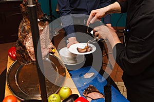 The chef prepares a meat dish from the wild boar