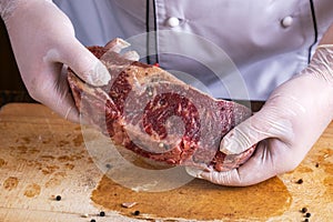 The chef prepares meat steak in his hands