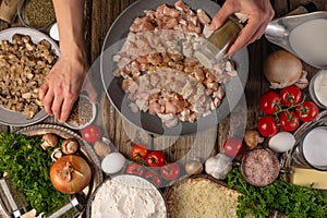 The chef prepares pizza with minced meat and mushrooms. In the photo, the cooking process. The chef adds spices to the filling. A