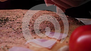 Chef prepares a pizza, putting ingredients on the dough. Frame. Traditional cooking of Italian pizza