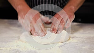 The chef prepares pizza on a white table