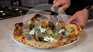 The chef prepares pizza on a white table