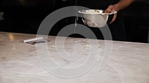 The chef prepares pizza on a white table