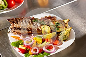 The chef prepares in the restaurant. Grilled rack of lamb with fried potatoes and fresh vegetables