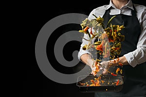 The chef prepares a salad, with a Pepper mill on a dark background with an empty space for writing