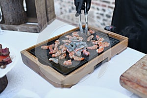 The chef prepares the shrimps on the plancha photo