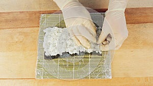 The chef prepares sushi by placing rice on the algae Nuri