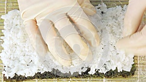 The chef prepares sushi by placing rice on the algae Nuri