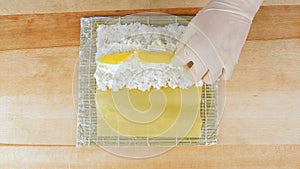 The chef prepares sushi by placing rice on the algae Nuri