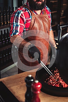 Chef preparing charcoals before grilling in a restaurant