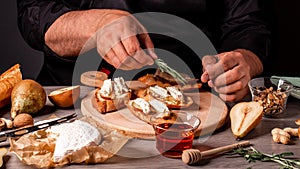 Chef preparing cheese, pear bruschetta in the kitchen. elicious breakfast or snack with brie camembert cheese