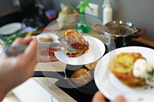 Chef preparing fried potato pancakes in frying pan closeup