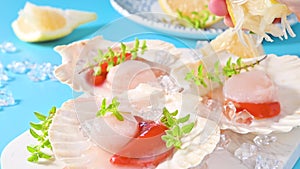 Chef preparing healthy gourmet food, seared scallops with caviar on on a beautiful dish in shellfish shells. A