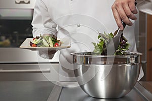 Chef Preparing Leaf Vegetables In Commercial Kitchen