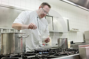 Chef preparing pancake dessert pouring dough into pan in kitchen