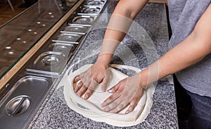 Chef preparing pizza dough hands. Pizza dough being rolled and kneaded. Cook hands kneading dough, sprinkling piece of