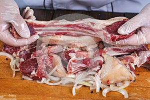 Chef preparing raw lamb chops for cooking separating the rack of lamb