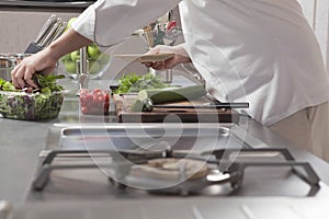 Chef Preparing Salad In Commercial Kitchen