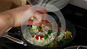 Chef preparing scrambled eggs with vegetables.