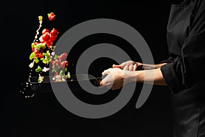 Chef preparing vegetables on a dark background on a grill pan