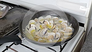 Chef presenting delicious clams in olive oil, garlic and chop onions