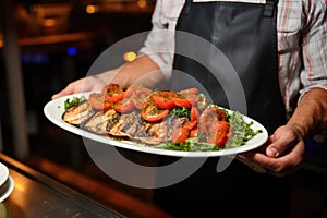 chef presenting a plate of grilled salmon steaks to customers