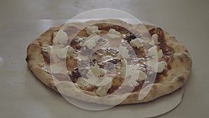 Chef puts sprinkles sliced meat on a pizza befor baking it in oven cooking