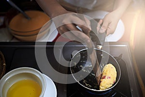 Chef putting egg to pan.