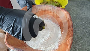 Chef putting the fish in flour ready to fry. Cooking fish. Hands close up.