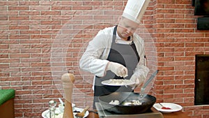 Chef putting fresh seafood to a pan