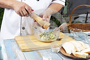 Chef putting pepper to bowl for cook garlic bread