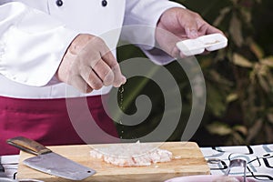 Chef putting Salt to the chicken befor cooking