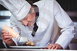 Chef putting sauce on a dish of spaghetti