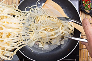 Chef putting Spaghetti for cooking with tongs