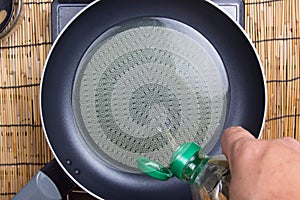 Chef putting vegetble oit to pan