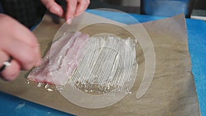 Chef putting white fish fillet on butter on Parchment Paper to bake