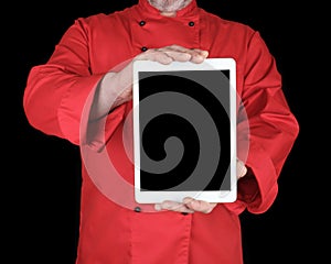 Chef in a red uniform holding a white electronic tablet with a black blank screen