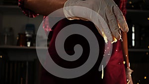 A chef in a red uniform and protective gloves is adding grated cheese in process of cooking in slowmo