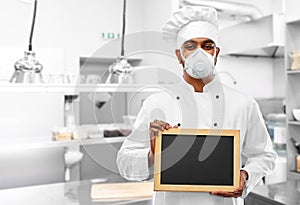 Chef in respirator with chalkboard at kitchen