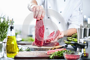 Chef cutting and cooking meat in the restaurant kitchen
